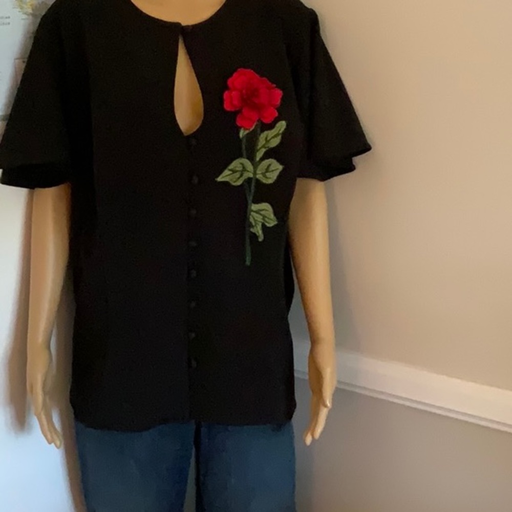 Plus size, black flutter sleeve top with red rose appliqué.